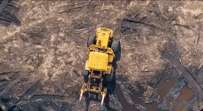 Aerial view of a yellow wheel loader on a muddy job site