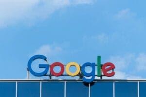 The Google logo in green, red, yellow, and blue letters on a glass building facade.