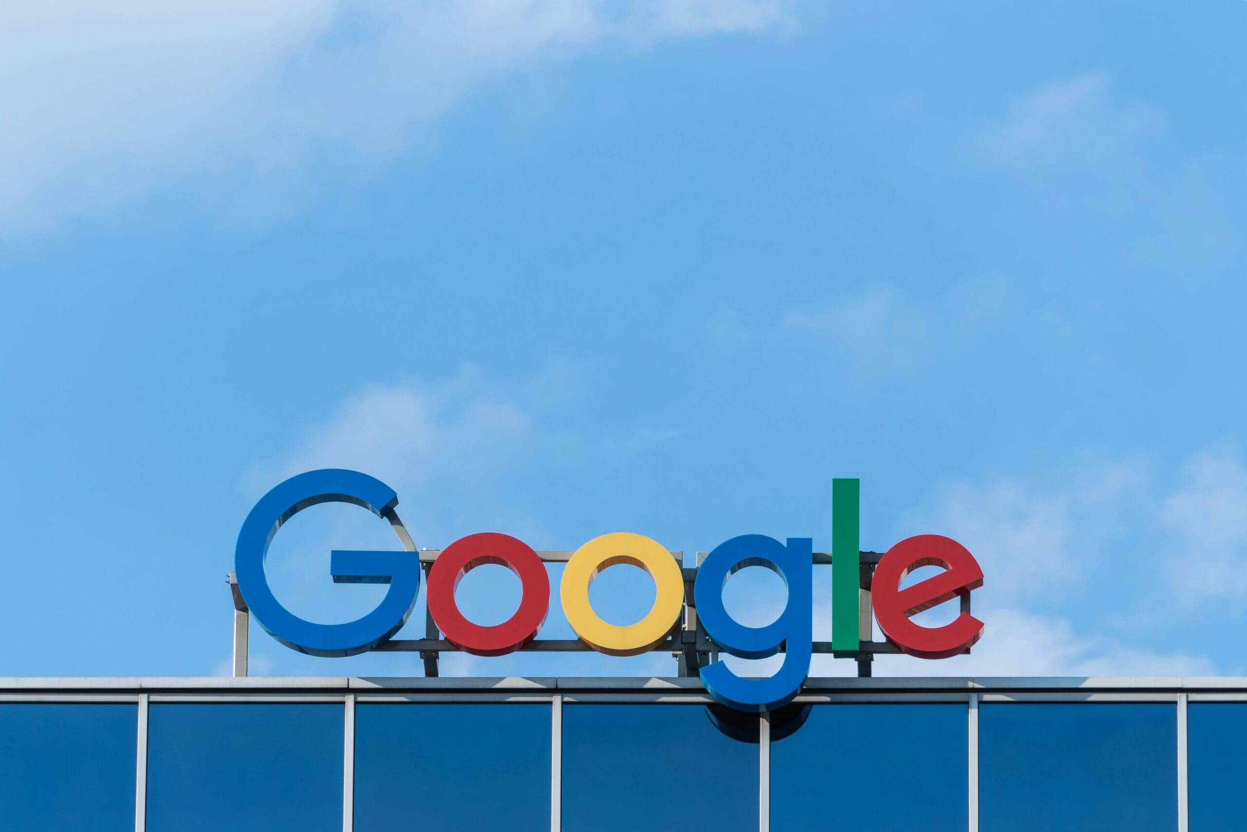 The Google logo in green, red, yellow, and blue letters on a glass building facade.