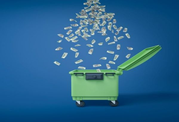 money raining down in green dumpster